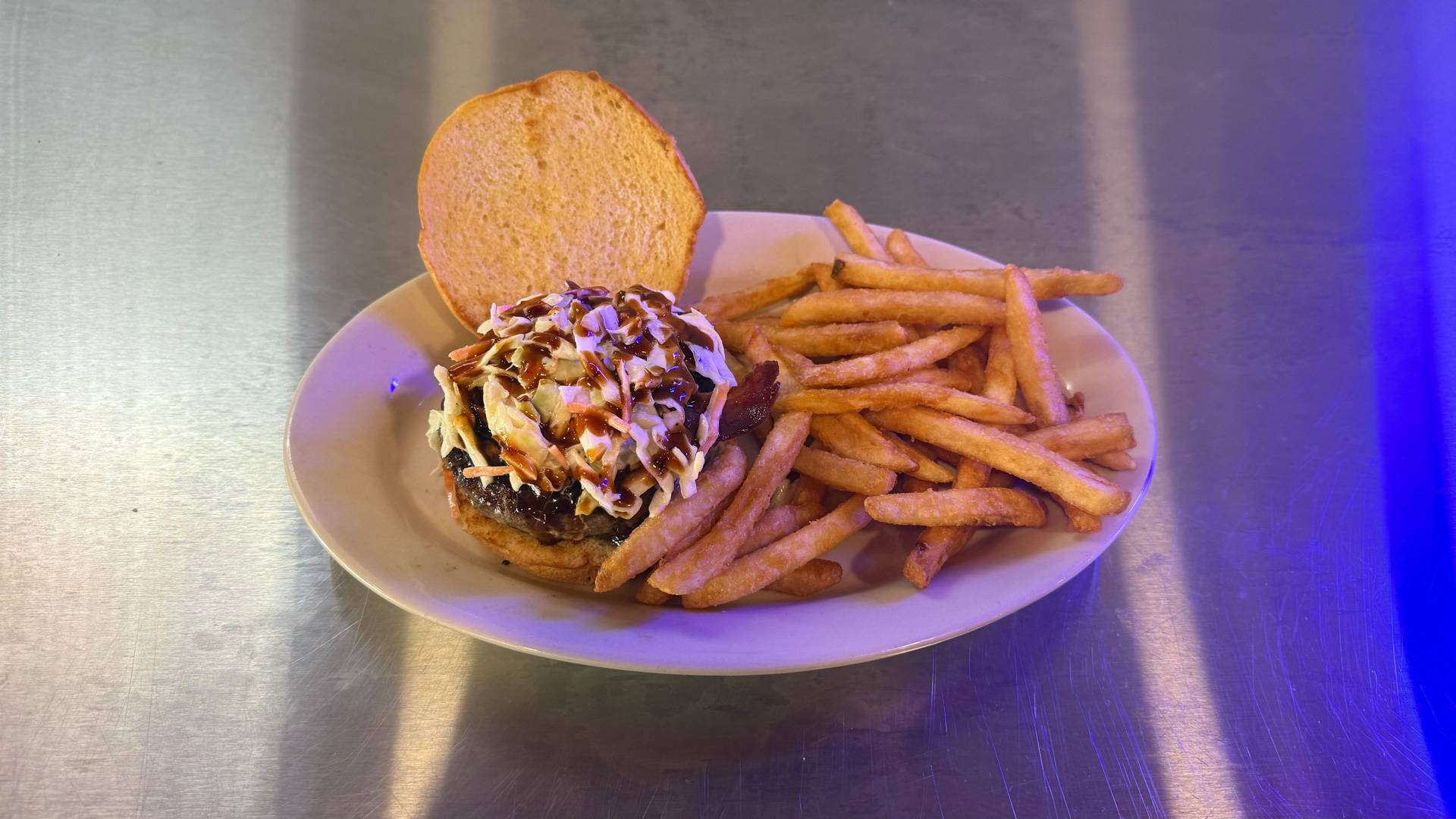 A juicy, mouthwatering Korean Burger at Brooks Burgers, topped with Korean BBQ sauce, kimchi, and fresh vegetables, served with crispy golden fries.