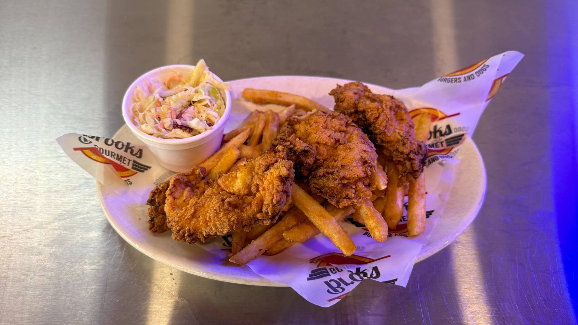A delicious chicken tender basket from Brooks Burgers, featuring crispy golden-brown tenders and a side of French fries, embodying the essence of American comfort food.