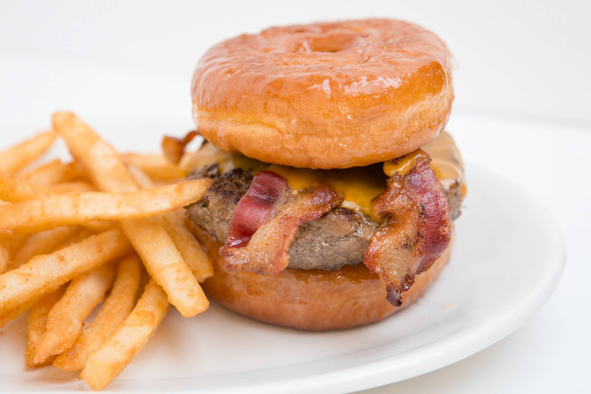A close-up image of Brooks Burgers' famous Donut Burger, featuring a juicy beef patty nestled between two glazed donuts, perfectly blending sweet and savory flavors.