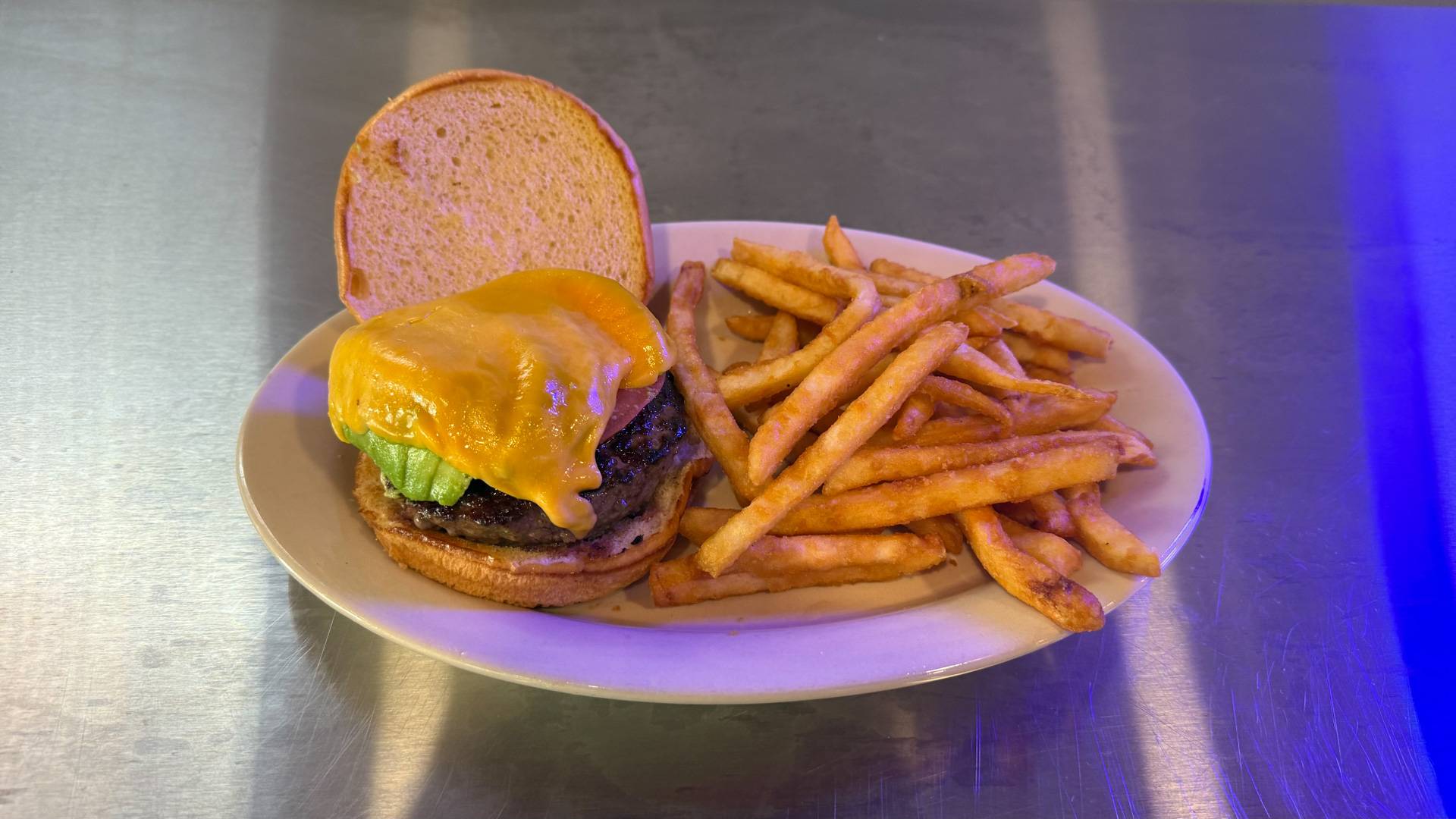 A mouthwatering burger from Brooks Burgers, featuring melted cheese, fresh lettuce, and a toasted bun, set against a vibrant dining atmosphere.