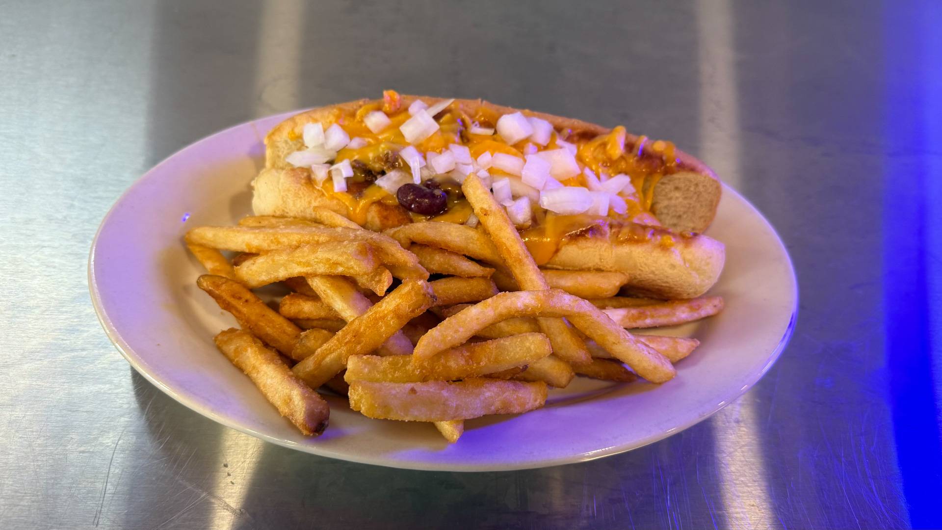 A delicious Brooks Burgers signature dish, the Chili Cheese and Onion Delight, showcasing a juicy burger topped with savory chili, melted cheese, and sautéed onions.
