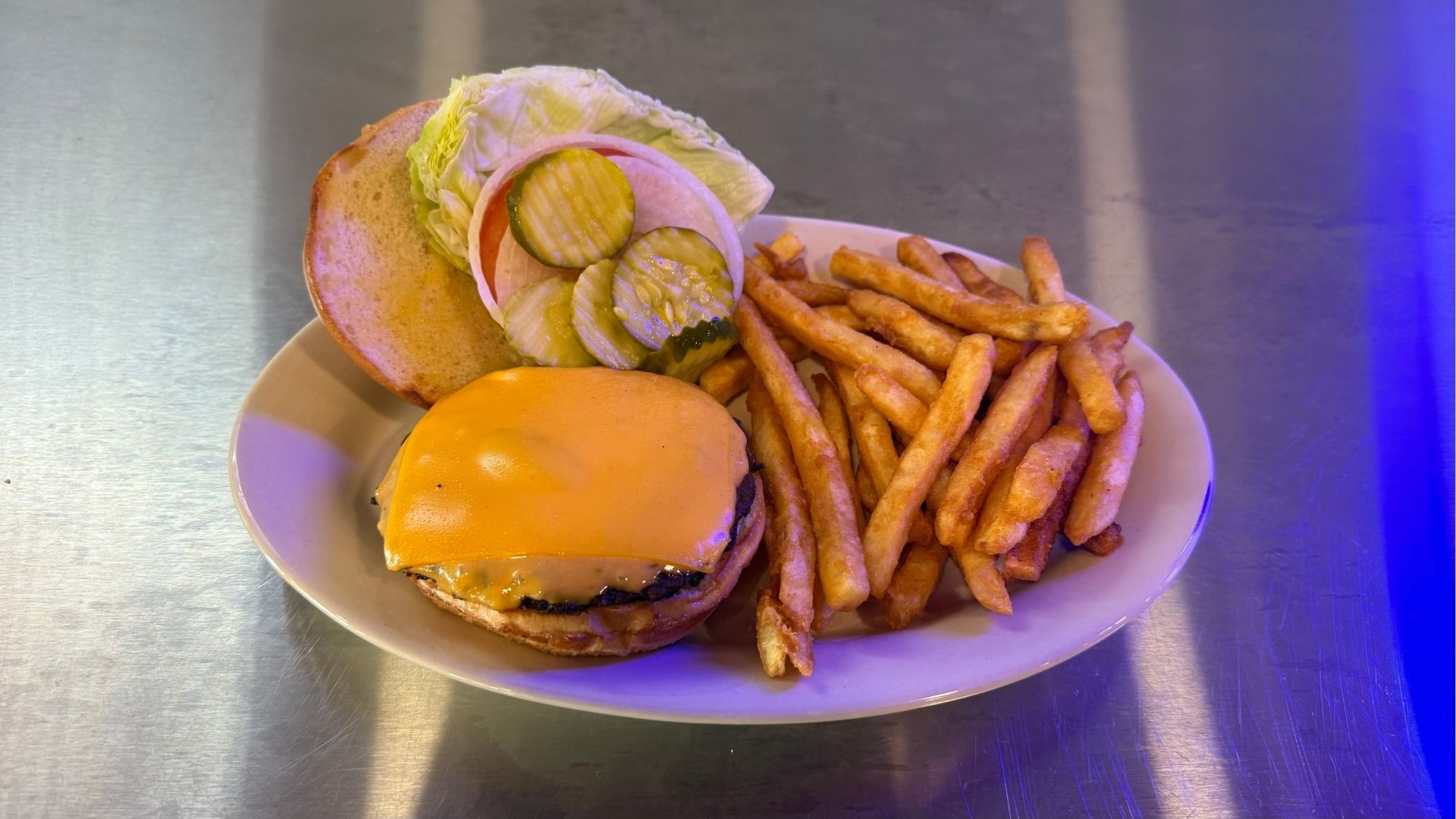 A juicy handcrafted burger with all the toppings served on a rustic wooden table at Brooks Burgers, showcasing the restaurant's premium dining atmosphere.