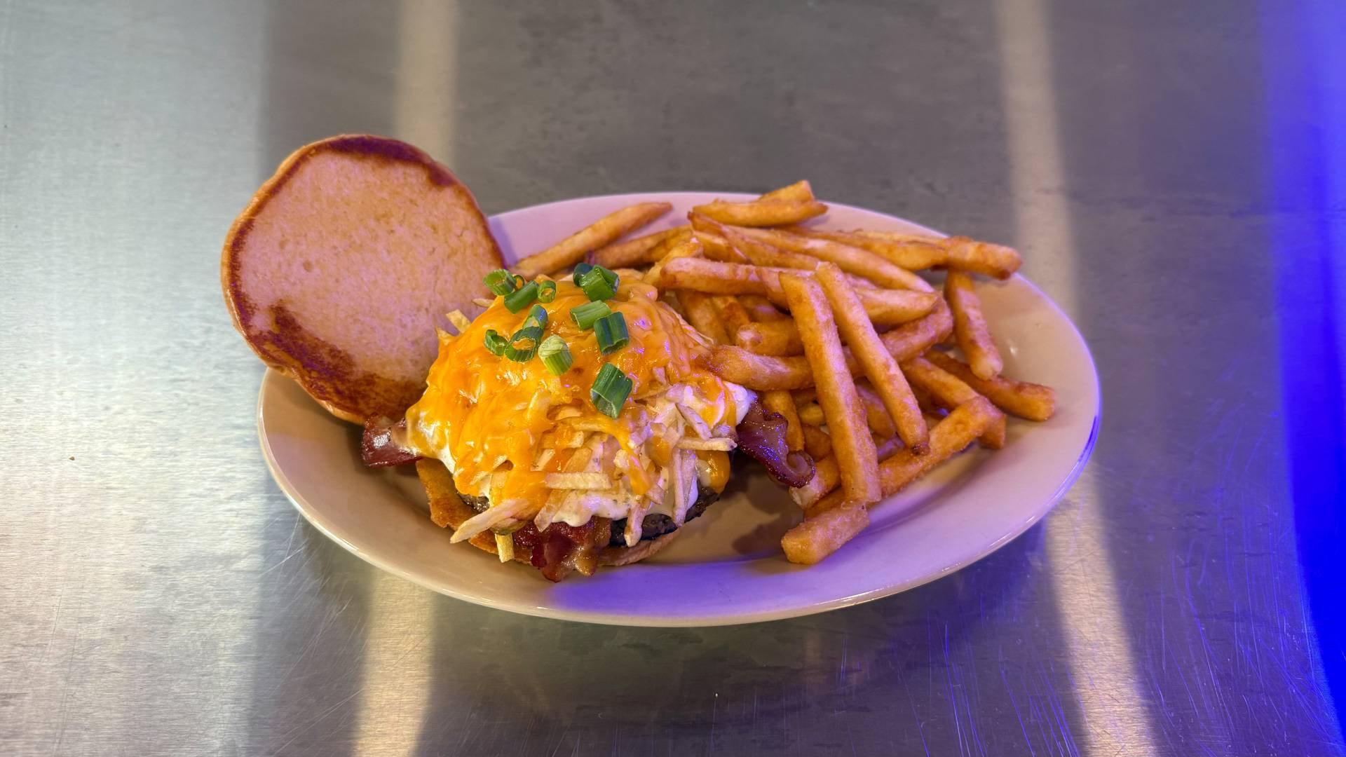 A Twice Baked Burger from Brooks Burgers in Naples, featuring a juicy patty and fresh toppings, set on a rustic wooden table surrounded by casual dining decor.