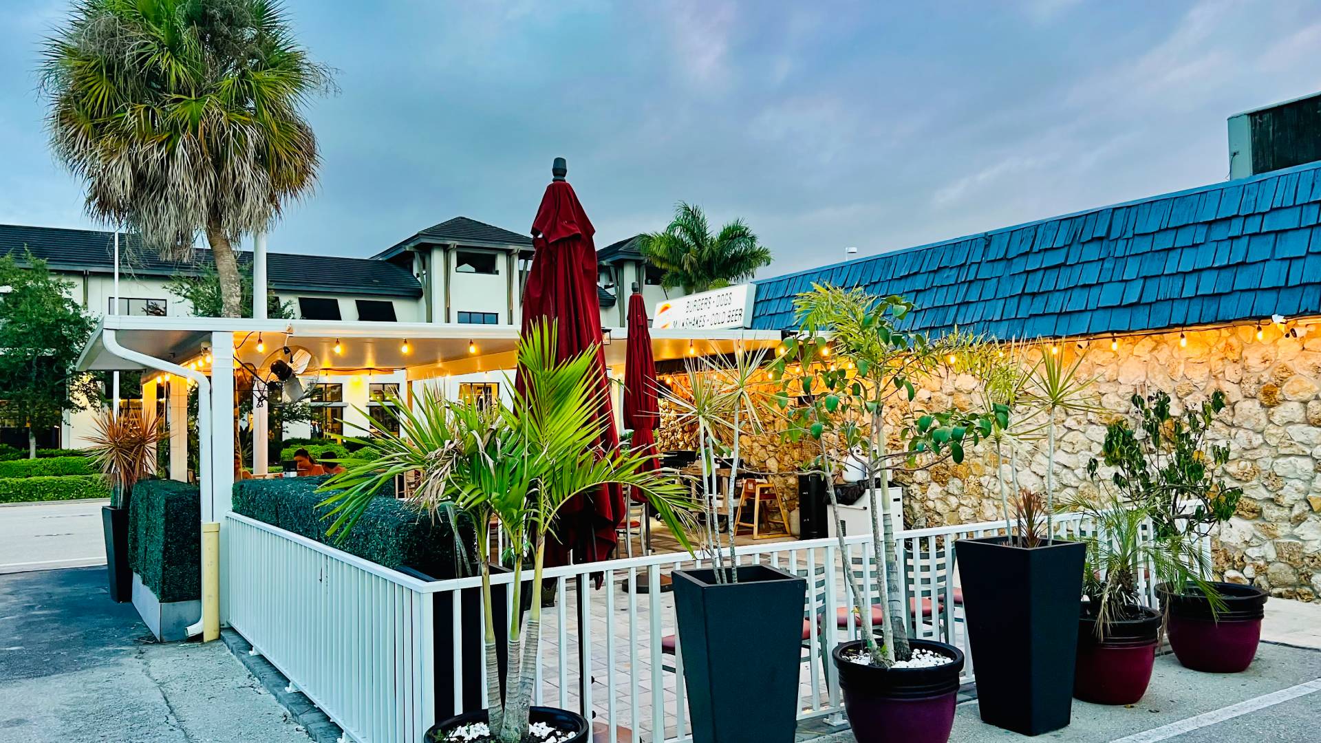 A delicious, handcrafted burger from Brooks Burgers stacked high with fresh ingredients, surrounded by a casual and vibrant dining atmosphere in downtown Naples.